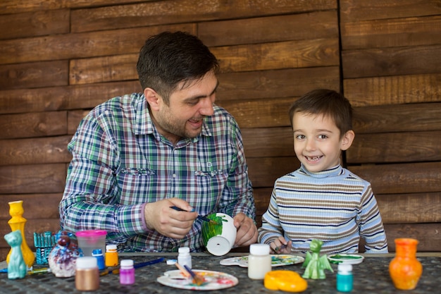 Pai e filho brincando com tintas coloridas