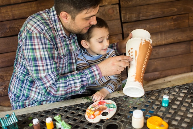 Pai e filho brincando com tintas coloridas