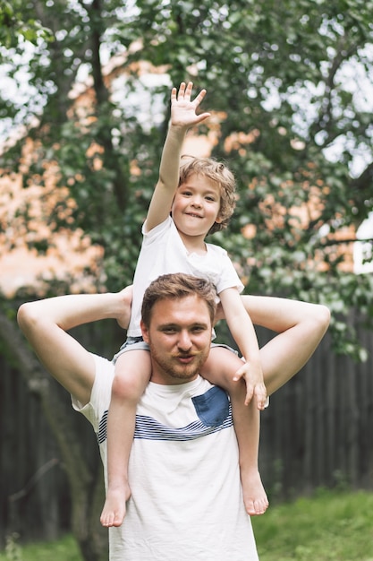 Foto pai e filho brincando e se abraçando ao ar livre