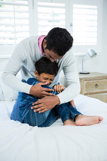 Pai e filho brincando na cama