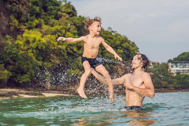 Pai e filho brincando na praia durante o dia