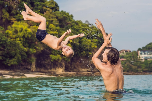 Pai e filho brincando na praia durante o dia