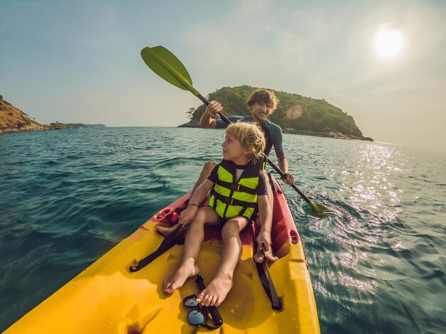 Pai e filho caiaque no oceano tropical.