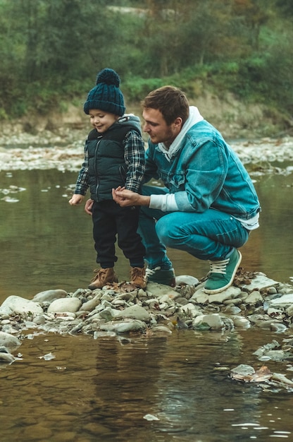 Pai e filho caminham e brincam juntos. o outono nas montanhas.