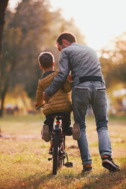 Pai e filho com bicicleta no parque