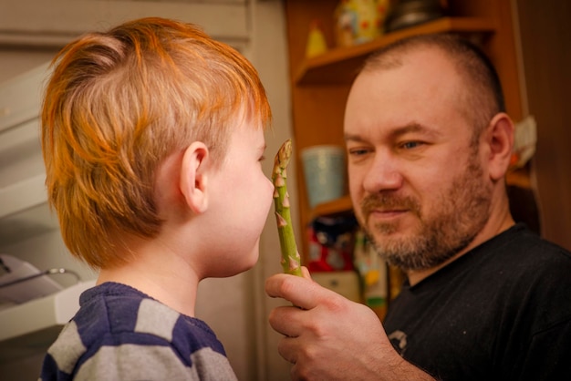 Pai e filho com conceito de comida saudável de espargos