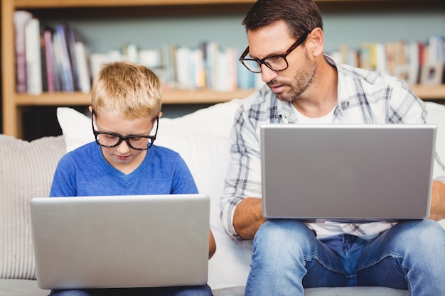 Pai e filho com óculos enquanto trabalhava no laptop