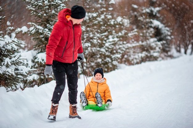 pai e filho com um trenó na neve