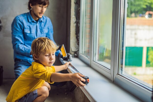 Pai e filho consertam janelas juntos Repare a casa você mesmo