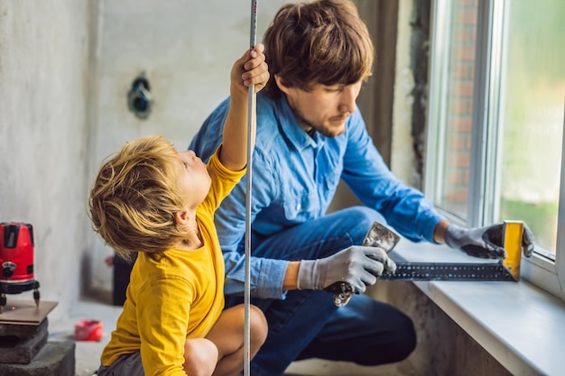 Pai e filho consertam janelas juntos Repare a casa você mesmo