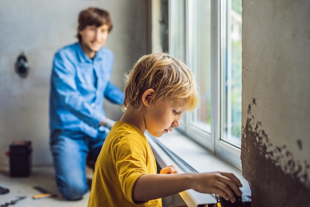 Pai e filho consertam janelas juntos Repare a casa você mesmo