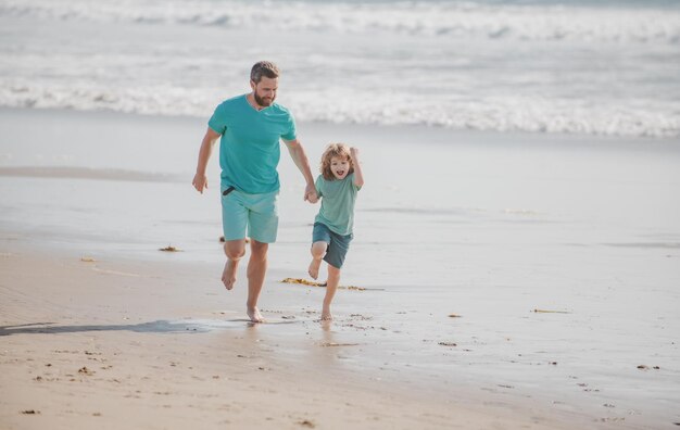 Pai e filho correndo na praia de verão pai e filho se divertindo ao ar livre