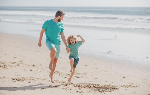 Pai e filho correndo no mar Conceito de família feliz