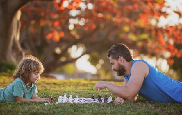 Pai e filho criança jogando xadrez passando tempo juntos ao ar livre