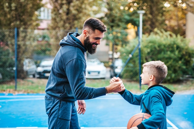 Pai e filho curtindo juntos na quadra de basquete.