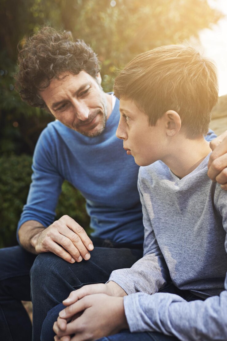 Foto pai e filho da família conversam no quintal, relacionando-se com amor e cuidado, comunicação e relacionamento. o homem ajuda dando conselhos a um menino adolescente em casa ao ar livre, com confiança e apoio