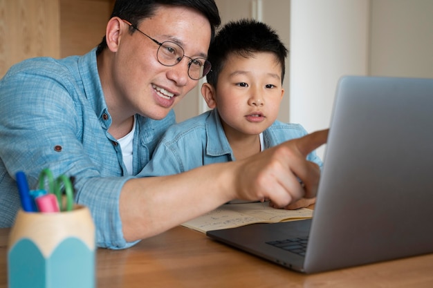 Pai e filho de tiro médio com laptop