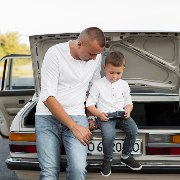 Foto pai e filho de tiro médio com smartphone