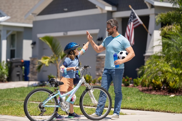 Pai e filho desfrutando de um passeio juntos Pai de apoio guiando filho filho primeiro passeio de bicicleta Pai e filho compartilhando aventura de bicicleta pai e filho percorrem o caminho juntos criando memórias