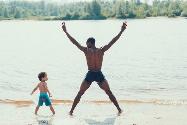 Pai e filho é exercitar em água na margem do rio