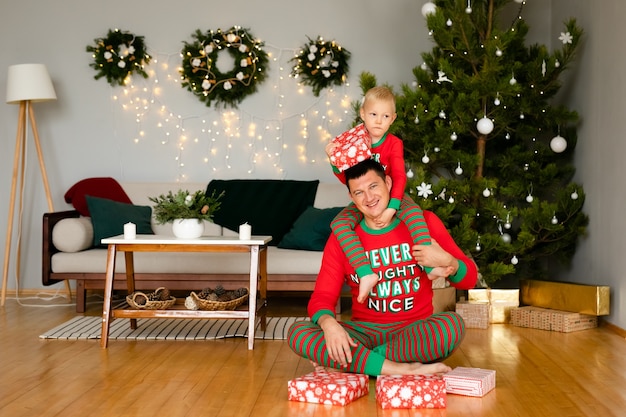 Pai e filho em pijamas aconchegantes desfazendo presentes