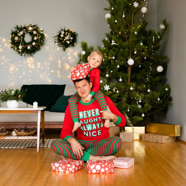 Pai e filho em pijamas aconchegantes desfazendo presentes