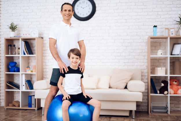 Pai e filho estão envolvidos em fitness em conjunto com fitball.