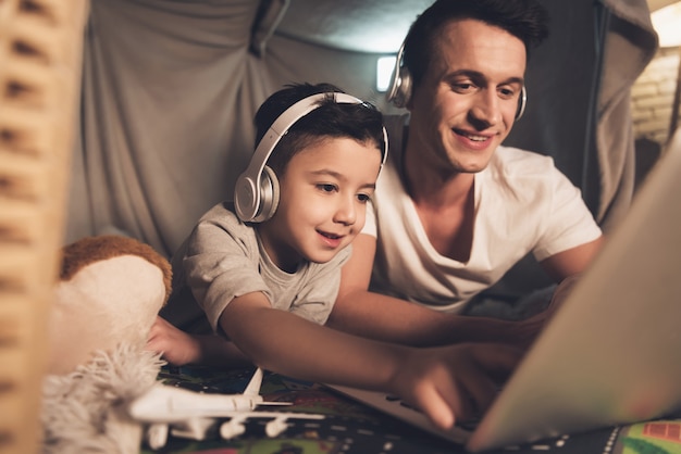 Pai e filho estão falando no skype para a família no laptop.