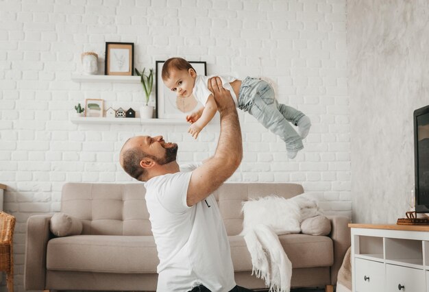 Pai e filho estão sorrindo enquanto passam tempo juntos pai e filho brincando em casa