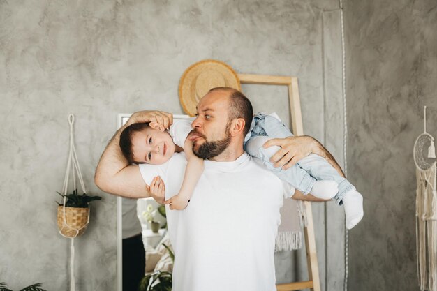 Foto pai e filho estão sorrindo enquanto passam tempo juntos pai e filho brincando em casa