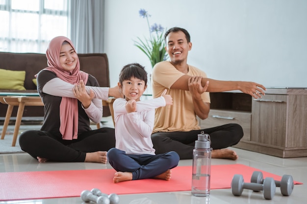 Pai e filho fazendo exercícios juntos. retrato de uma família muçulmana saudável fazendo exercícios em casa