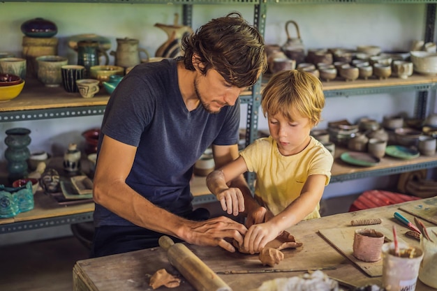 Pai e filho fazendo pote de cerâmica na oficina de cerâmica