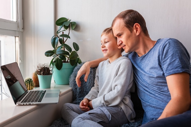 Pai e filho fazendo videochamada com os avós no laptop Fique em casa, conceito de comunicação à distância