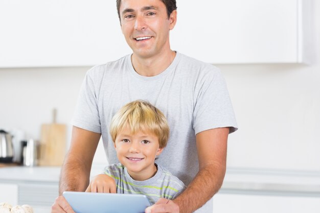 Pai e filho felizes usando tablet computador