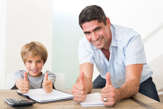 Pai e filho gesticulando polegares enquanto fazes a lição de casa