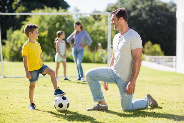 Pai e filho jogando futebol no parque