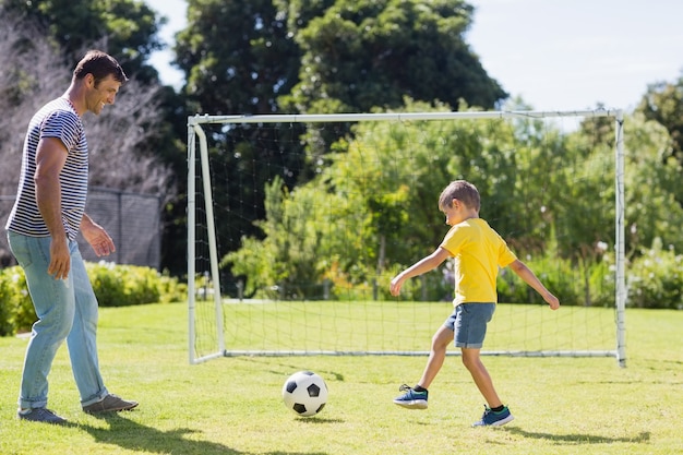 Pai e filho jogando futebol no parque