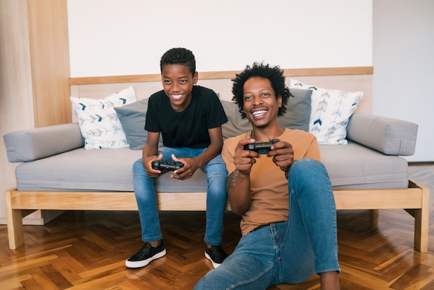 Pai e filho jogando videogame juntos em casa.