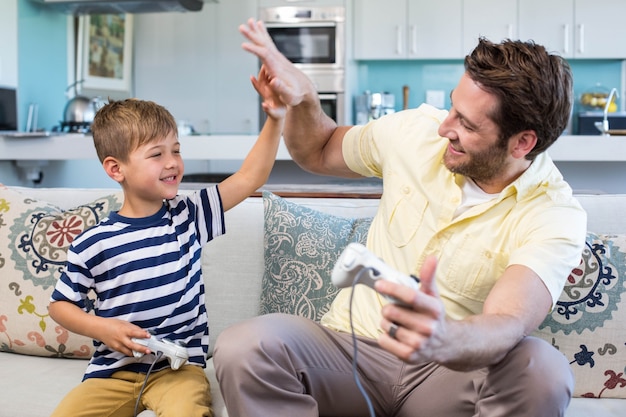 Foto pai e filho jogando videogames em conjunto