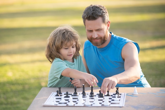 Pai e filho jogando xadrez passando tempo juntos criança ao ar livre joga xadrez