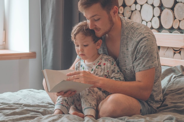 Pai e filho leram um livro juntos, sorrindo e se abraçando