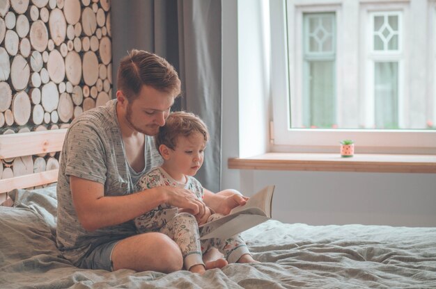 Pai e filho leram um livro juntos, sorrindo e se abraçando