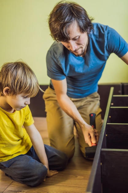 Pai e filho montando móveis Menino ajudando seu pai em casa Conceito de família feliz