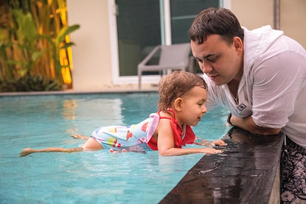 Foto pai e filho na piscina.