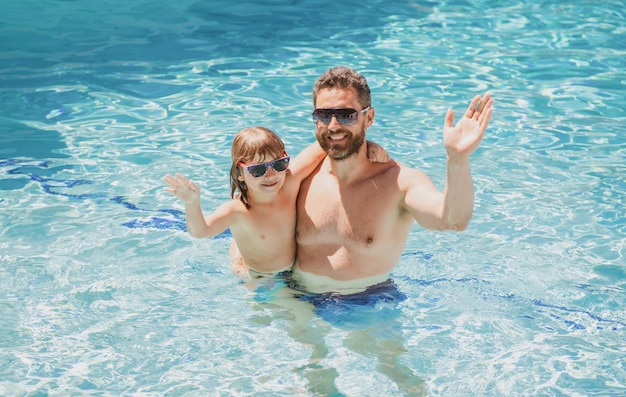 Pai e filho nadando na piscina, família de verão. Criança com o pai brincando na piscina. Parque aquático. Pai e filho lazer.