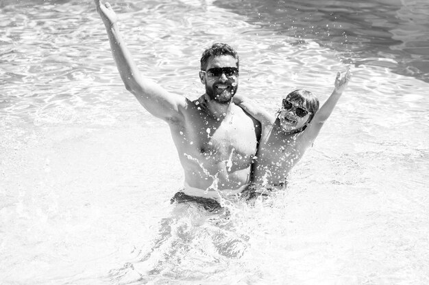 Pai e filho nadando na piscina, família de verão. fim de semana ativo.