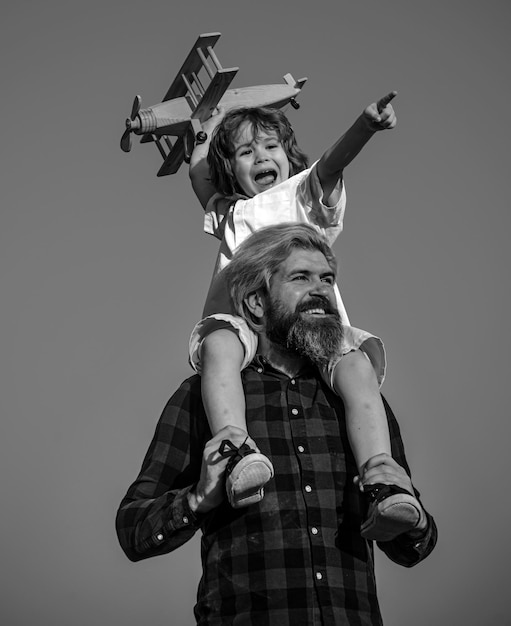 Foto pai e filho no dia dos pais conceito de família amigável pai e filho brincando com avião de brinquedo em