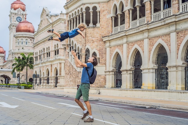 Pai e filho no fundo do edifício Sultan Abdul Samad em Kuala Lumpur Malásia Viajando com o conceito de crianças