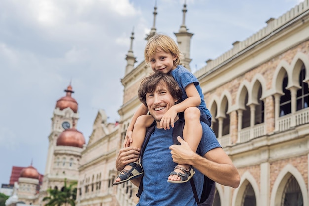 Pai e filho no fundo do edifício Sultan Abdul Samad em Kuala Lumpur Malásia Viajando com o conceito de crianças