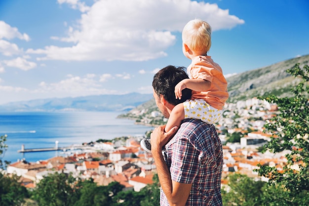 Pai e filho nos fundos da costa e da vila croata Conceito de férias e viagens em família